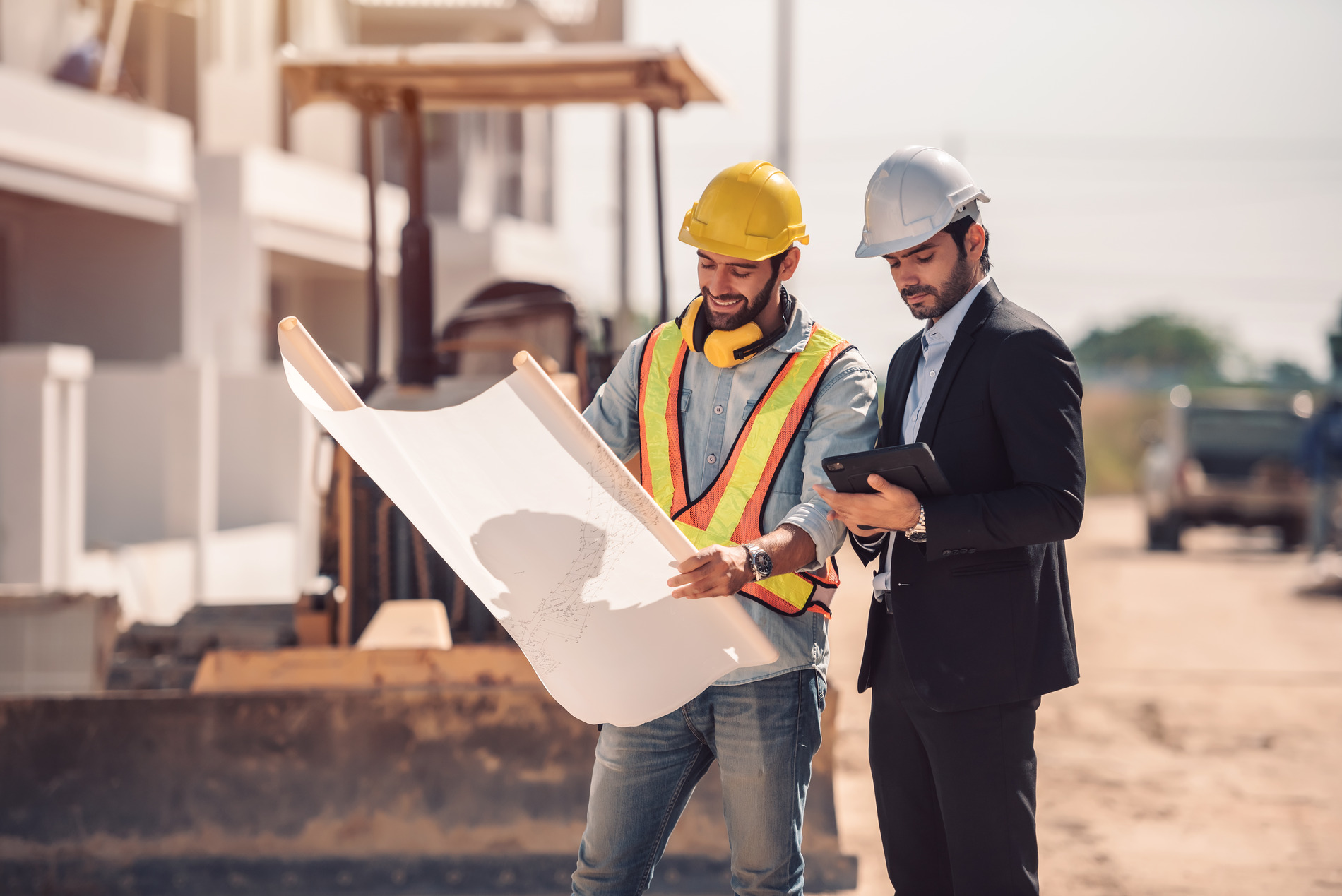 civil-engineer-construction-worker-manager-holding-digital-tablet-blueprints-talking-planing-about-construction-site-cooperation-teamwork-concept (1)